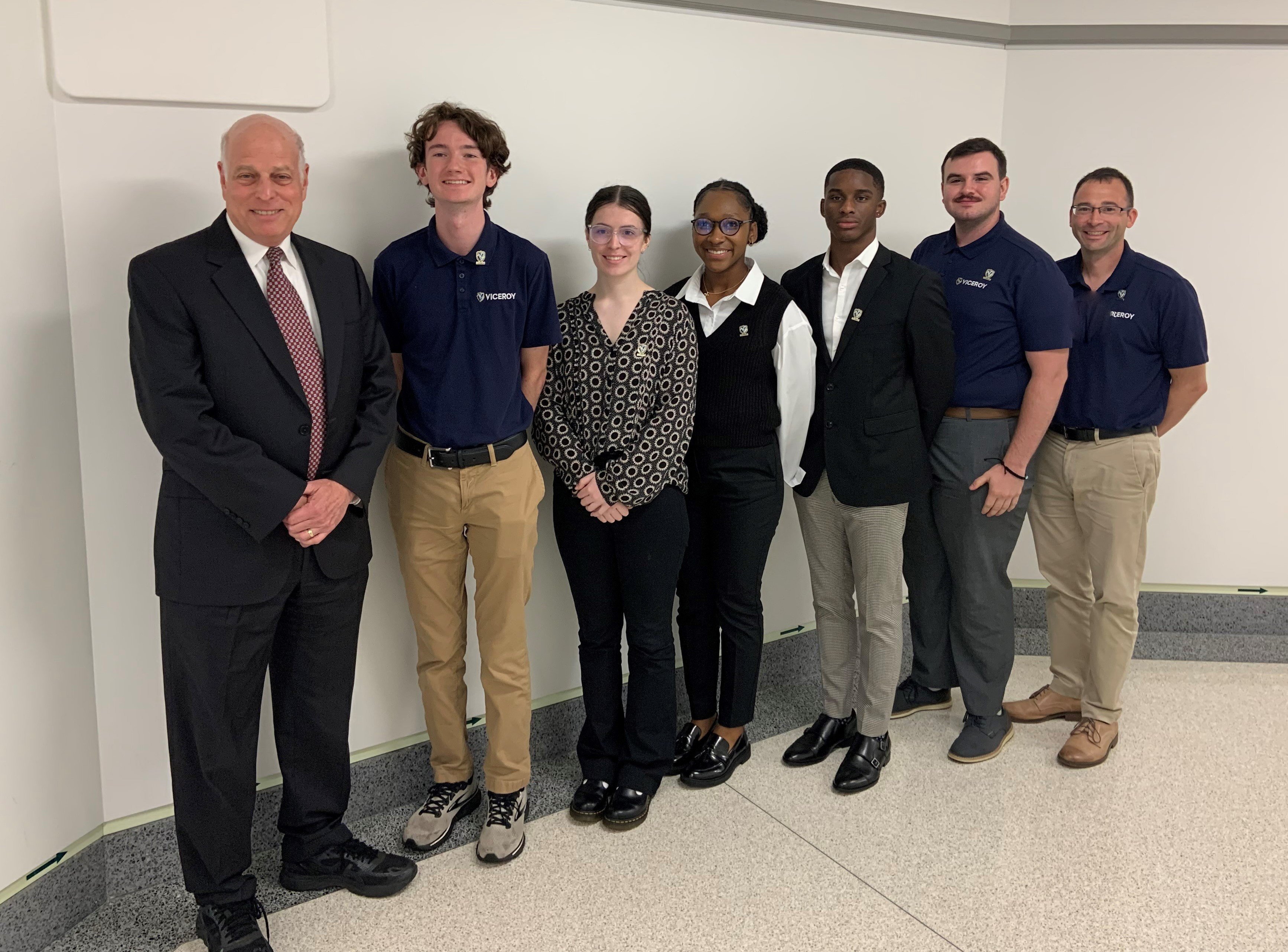 Deputy Under Secretary for Research and Engineering Dr. David A. Honey, left, greets graduates of the MAVEN internship program, left to right, Alexander Hagood, Guinevere Fish, Yasmin Chambers, Elijah Gartrell, Turner Woodward, and Benjamin Rosenberg, Aug. 17, 2023.