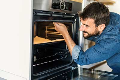 Man inspecting interior of oven after installation