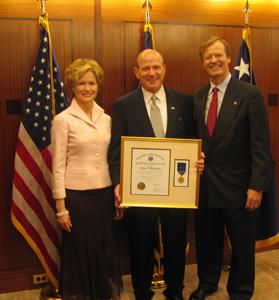 Bob McFarland (center), honored by the VA, accompanied by his wife Susan and Scott Higgins (right).